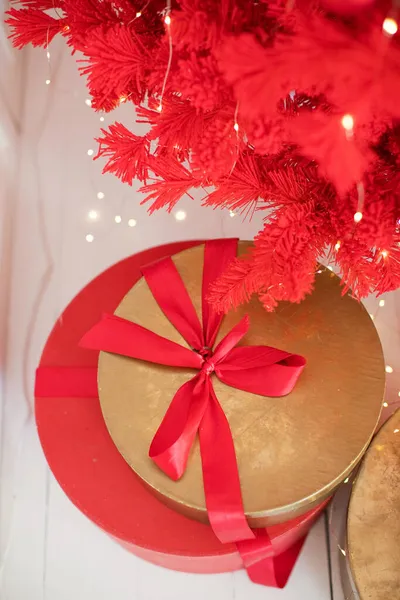 Червоні Золоті Різдвяні Подарункові Коробки Стрічками Біля Червоної Ялинки — стокове фото