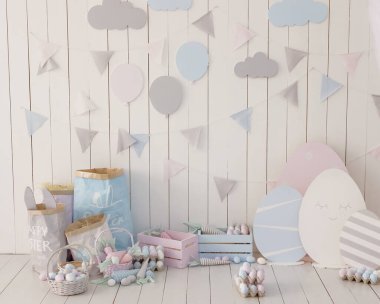 Açık Paskalya iç dekorasyonları mavi ve pembe. Tahta kutular, yumurtalı sepetler ve beyaz tahta duvarlı bayraklı çelenkler. Paskalya desenli çocuk odası