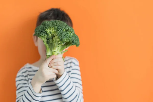 Barn Med Grön Grönsaksbroccoli Orange Bakgrund Med Kopieringsutrymme Friska Livsmedel — Stockfoto