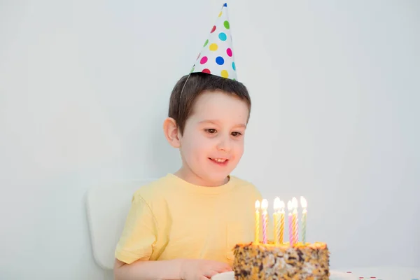 Menino Caucasiano Criança Chapéu Aniversário Colorido Sentado Perto Bolo Aniversário — Fotografia de Stock