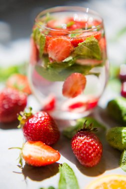 Taze yaz meyve kokteyli. Gri beton arka planda yaz içeceği. Çilekli, kirazlı ve naneli moktail.