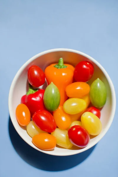 Miska Małymi Pomidorami Papryką Niebieskim Tle Przestrzenią Kopiowania Koncepcja Świeżych — Zdjęcie stockowe