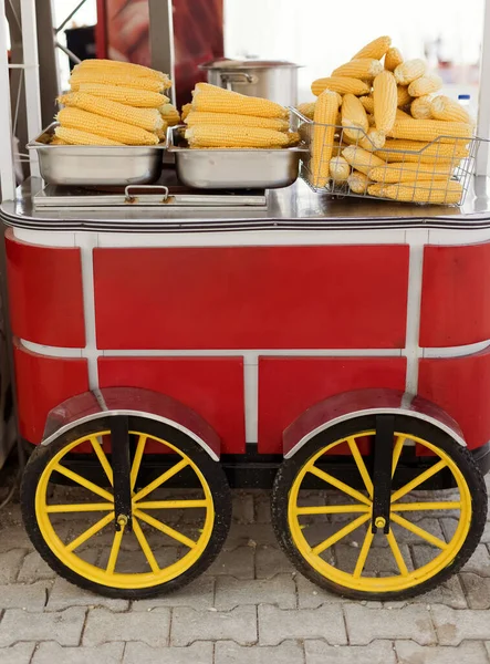 Red food truck with ripe corn cob. Food market concept, tasty yellow corn