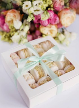 Makaronlar ve çiçek buketleriyle dolu bir kutu beyaz bir arkaplanda kopya alanı ile