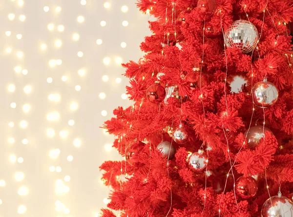 Red Christmas tree with golden decorations and lights garland