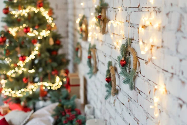 Julkransar Med Ljus Och Röda Dekorationer Hängande Tegelvägg Nära Julgran — Stockfoto