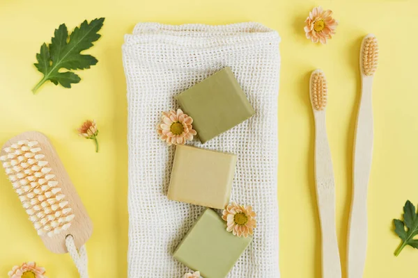 Natural wooden brush Eco cosmetics products and tools on a yellow background. Zero waste, Plastic free. Sustainable lifestyle concept.