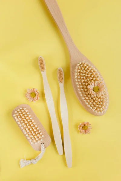 Natural wooden brush Eco cosmetics products and tools on a yellow background. Zero waste, Plastic free. Sustainable lifestyle concept.