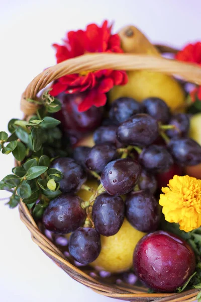 Weidenkorb Mit Früchten Und Blumen Auf Lila Hintergrund Nahaufnahme — Stockfoto
