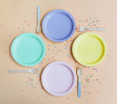 Konfeti ile bej bir zemin üzerinde boş renkli plakalar ile parti tablo ayarı, kopyalama alanı