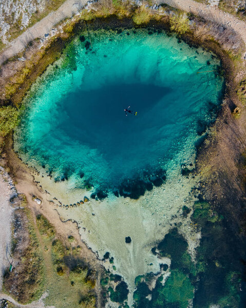 One diver in the blue hole Izvor Cetine, Dalmatia. Aerial top down shot in April, 2021.
