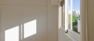 Sütun ve güneş ışığına sahip beyaz bir duvarın önünde boş küçük oda şehrin ön duvarında sokak referans penceresi olan bir pencere çiz.