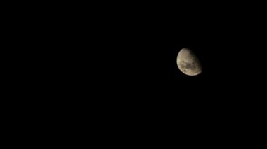 Ay yükselen safhada sepia güneş ışığını kraterlerle yüzeyinden yansıtır. Güney yarımküredeki karanlık gece gökyüzüne ve çerçevenin sağ üst çeyreğine karşı..