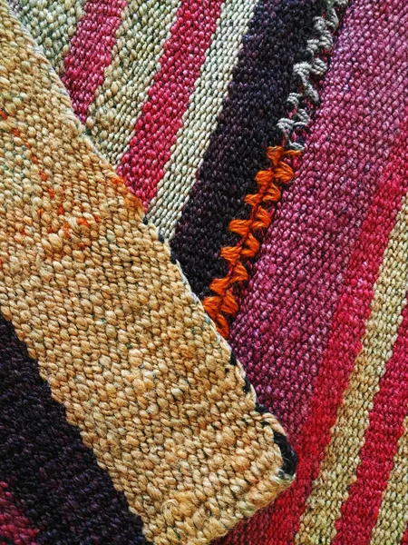 Traditional Andean craft weaving plot colled Aguayo, made it with llama wool on a manual loom, viewed from above and in close up.