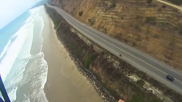 太平洋岸を飛ぶパラグライダーとカメラの女性とインストラクターの参照 — ストック動画