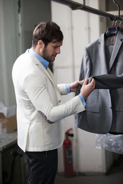 Knappe man winkelen voor kleding in een winkel. — Stockfoto