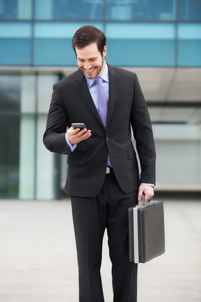 Smiling businessman looking at the phone — Stock Photo, Image