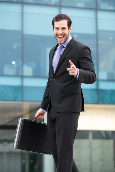 Smiling businessman in front of an office building — Stock Photo, Image