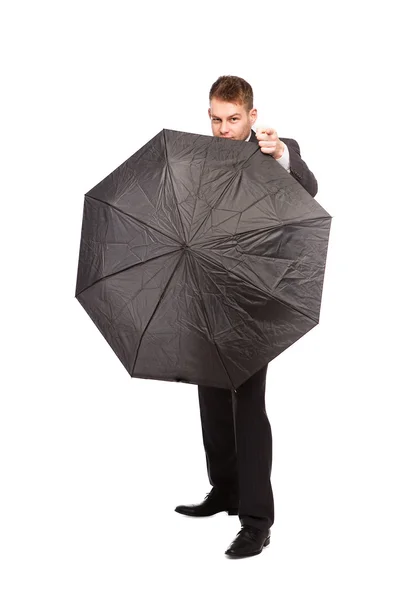 Businessman pointing behind an umbrella — Stock Photo, Image