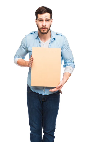 Jovem homem bonito casual vestido com painel de madeira em branco — Fotografia de Stock