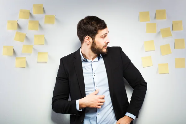 Mann steht neben einer Mauer mit Postings — Stockfoto