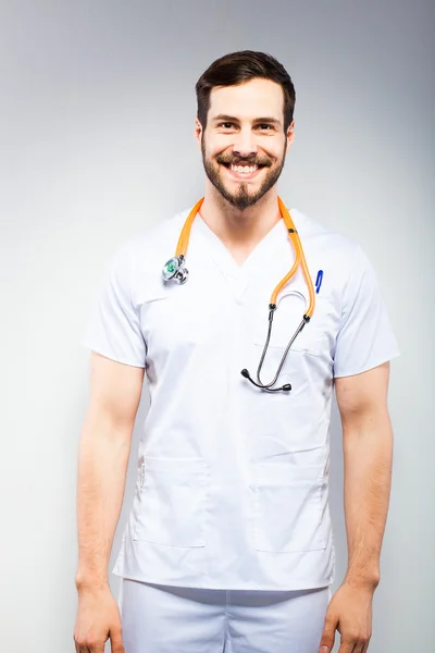 Handsome doctor standing next to wall — Stock Photo, Image