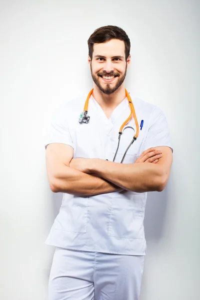 Bonito médico de pé ao lado da parede — Fotografia de Stock