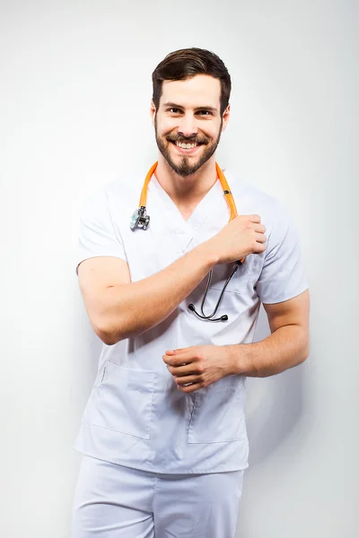 Handsome doctor standing next to wall — Stock Photo, Image