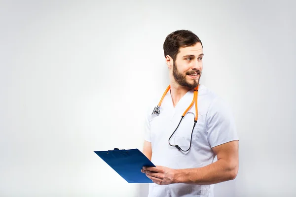 Bonito médico de pé ao lado da parede — Fotografia de Stock