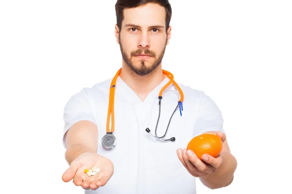 Homme Docteur montrant orange et pilules — Photo