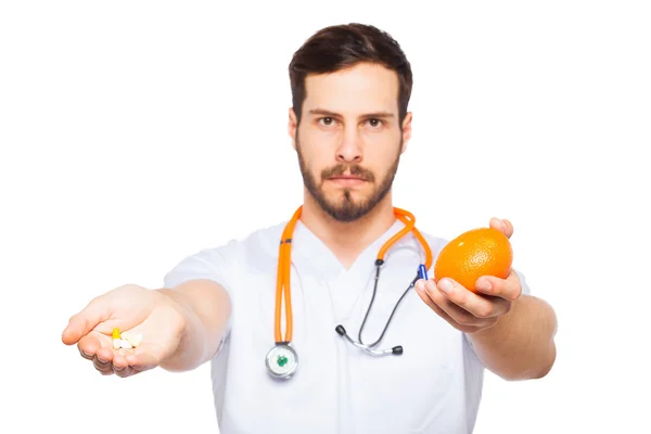 Homme Docteur montrant orange et pilules — Photo