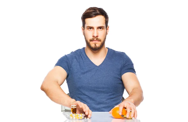 Man having in front pills and fruits, Choosing between them — Stock Photo, Image