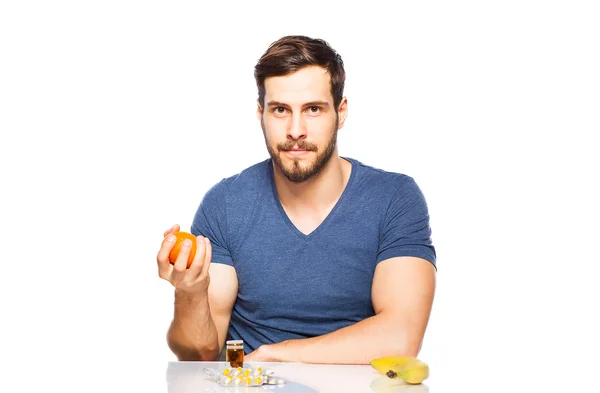 Man having in front pills and fruits, Choosing between them — Stock Photo, Image