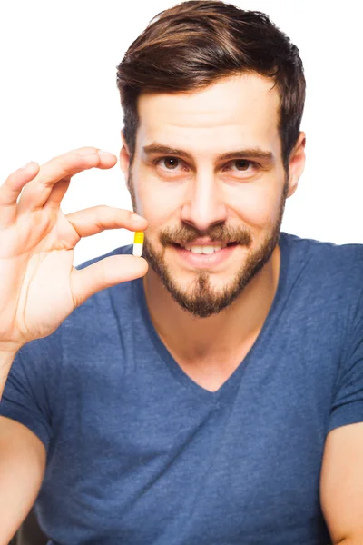 Красивый мужчина показывает таблетки — стоковое фото