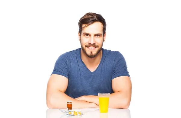 Man having in front pills and orange juice — Stock Photo, Image