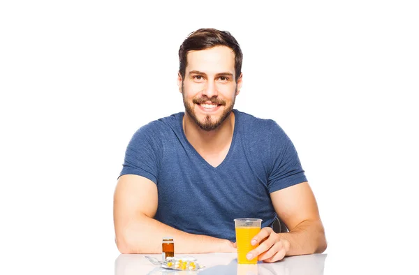 Hombre teniendo en frente píldoras y jugo de naranja —  Fotos de Stock