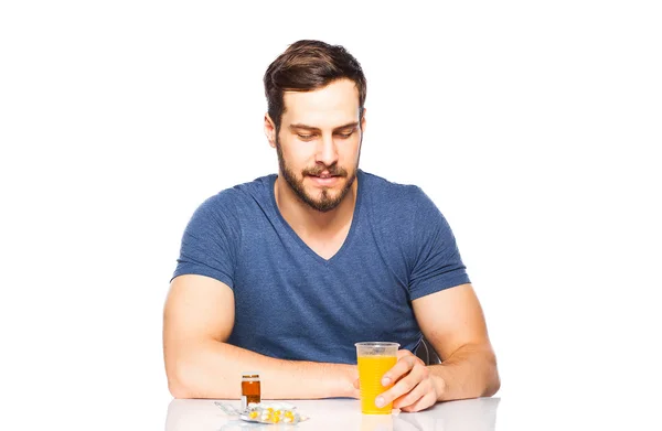 Hombre teniendo en frente píldoras y jugo de naranja —  Fotos de Stock