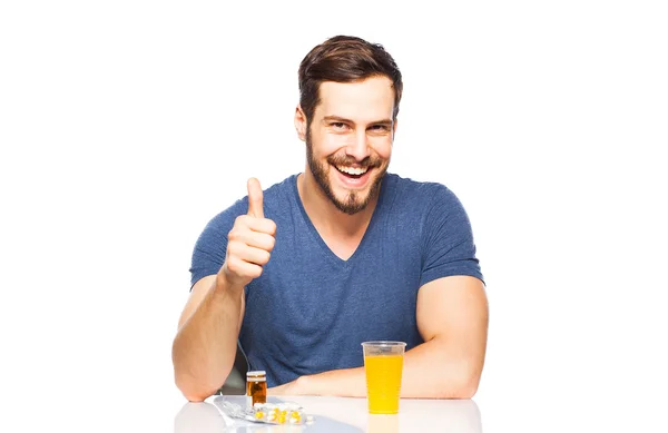 Hombre teniendo en frente píldoras y jugo de naranja —  Fotos de Stock