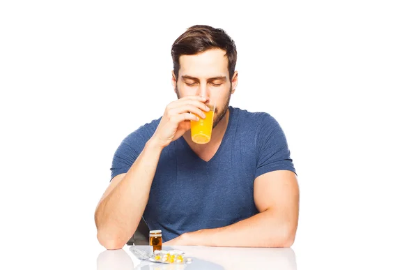 Man having in front pills and orange juice — Stock Photo, Image