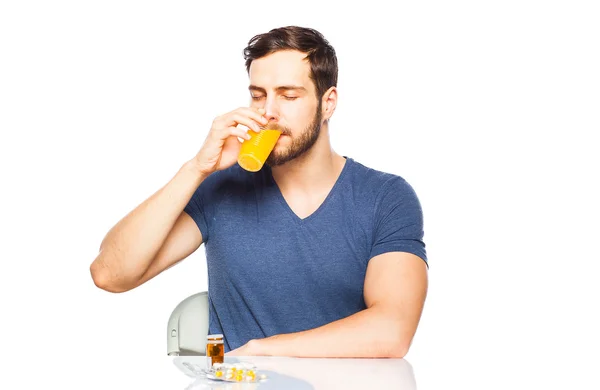 Man met vooraan pillen en jus d'orange — Stockfoto