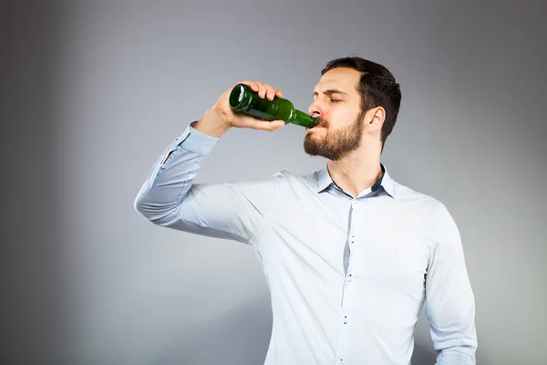 Retrato de un joven inteligente y serio bebiendo cerveza — Foto de Stock