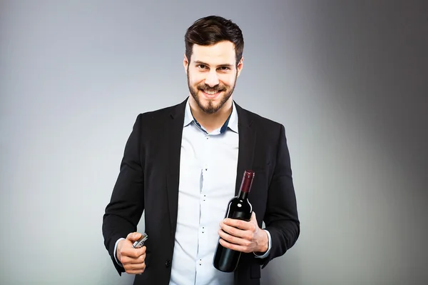 Handsome man opening bottle of wine — Stock Photo, Image