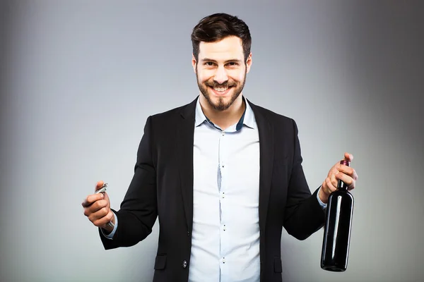 Handsome man opening bottle of wine — Stock Photo, Image