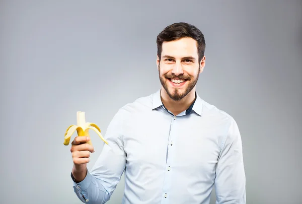 Ritratto di un giovane intelligente e serio che mangia banana — Foto Stock