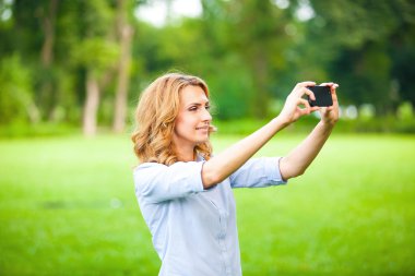 Güzel kadın smartphone ile fotoğraf çekmek