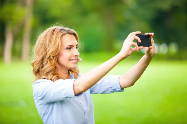 Mujer agradable tomando fotos con teléfono inteligente —  Fotos de Stock