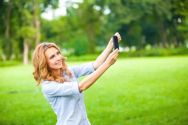 Милая женщина фотографирует со смартфона — стоковое фото