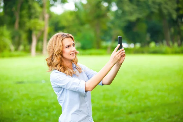 Mujer agradable tomando fotos con teléfono inteligente — Foto de Stock