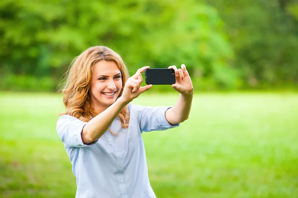 Mulher agradável tirar fotos com smartphone — Fotografia de Stock