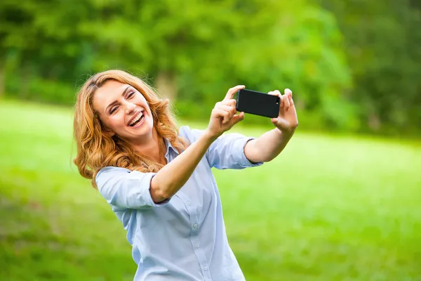 Nette Frau, die Fotos mit dem Smartphone macht — Stockfoto